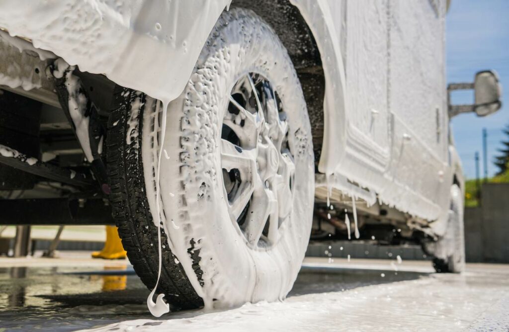 An RV being cleaned is covered in sudsy, soapy water.